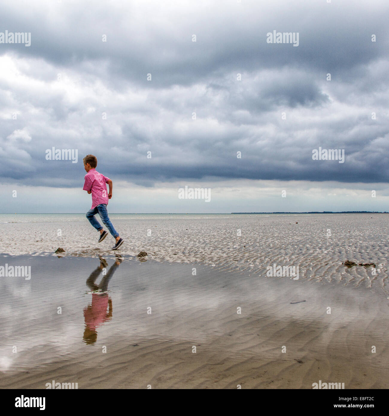 Niño corriendo en la playa Foto de stock