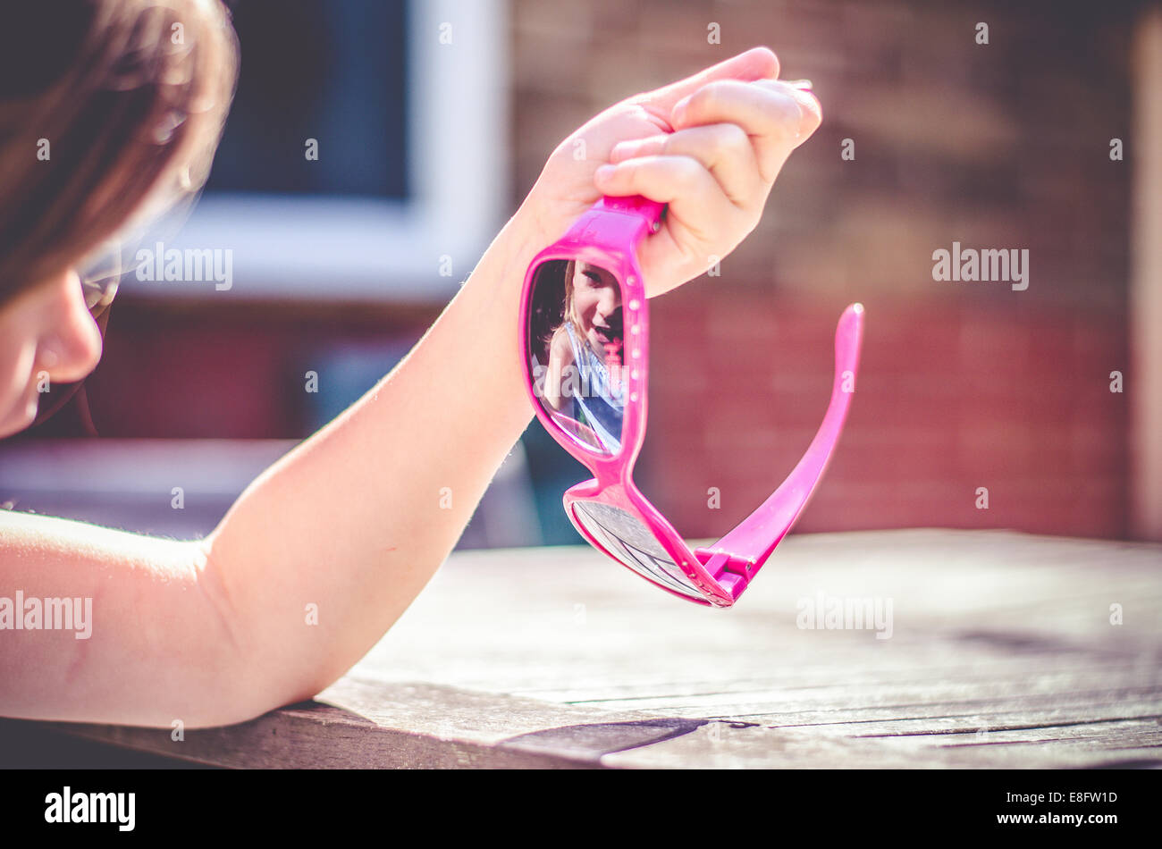 Chica mirando su reflejo en sus gafas de sol Foto de stock