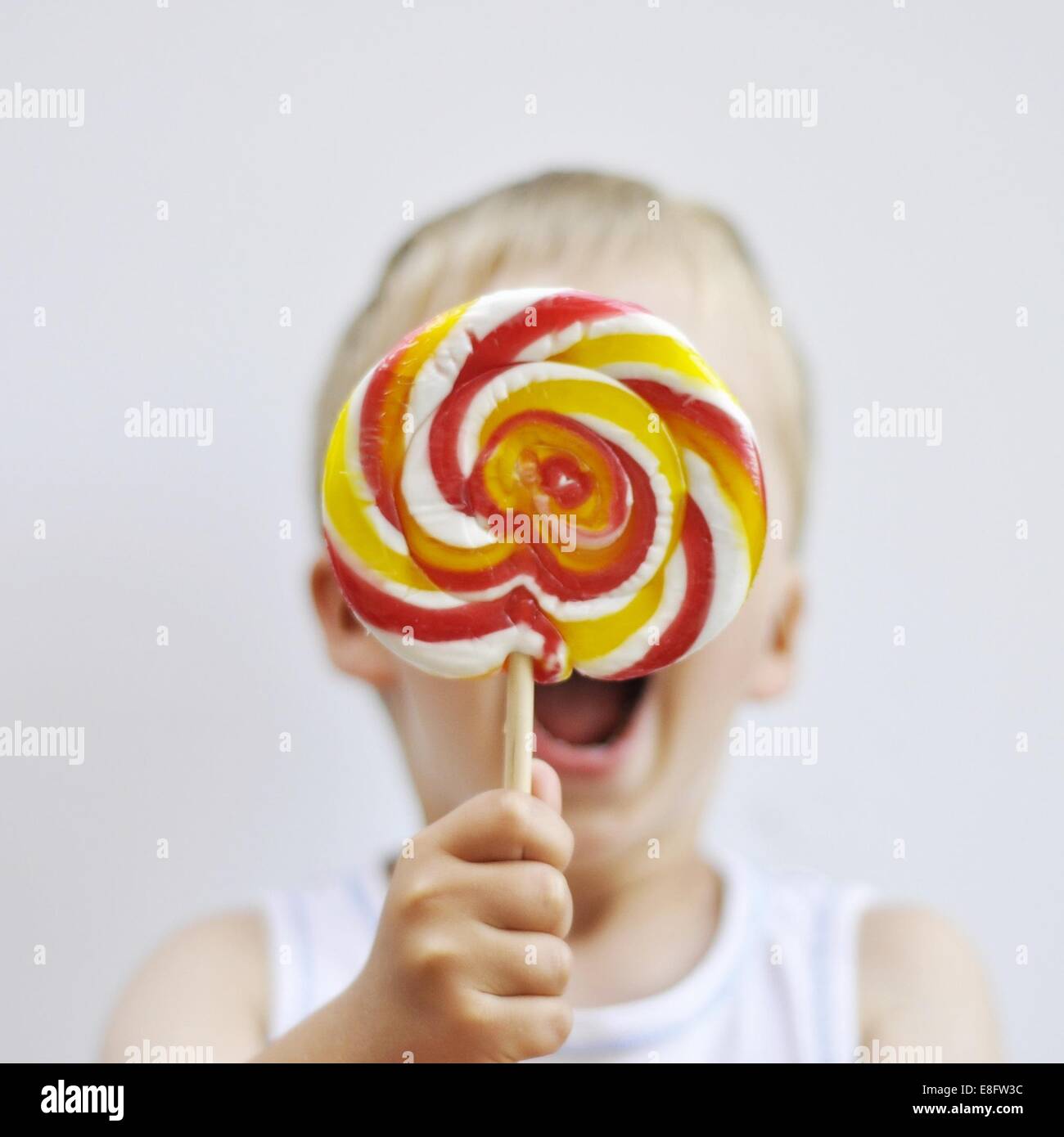 Niño sosteniendo una piruleta gigante Fotografía de stock - Alamy