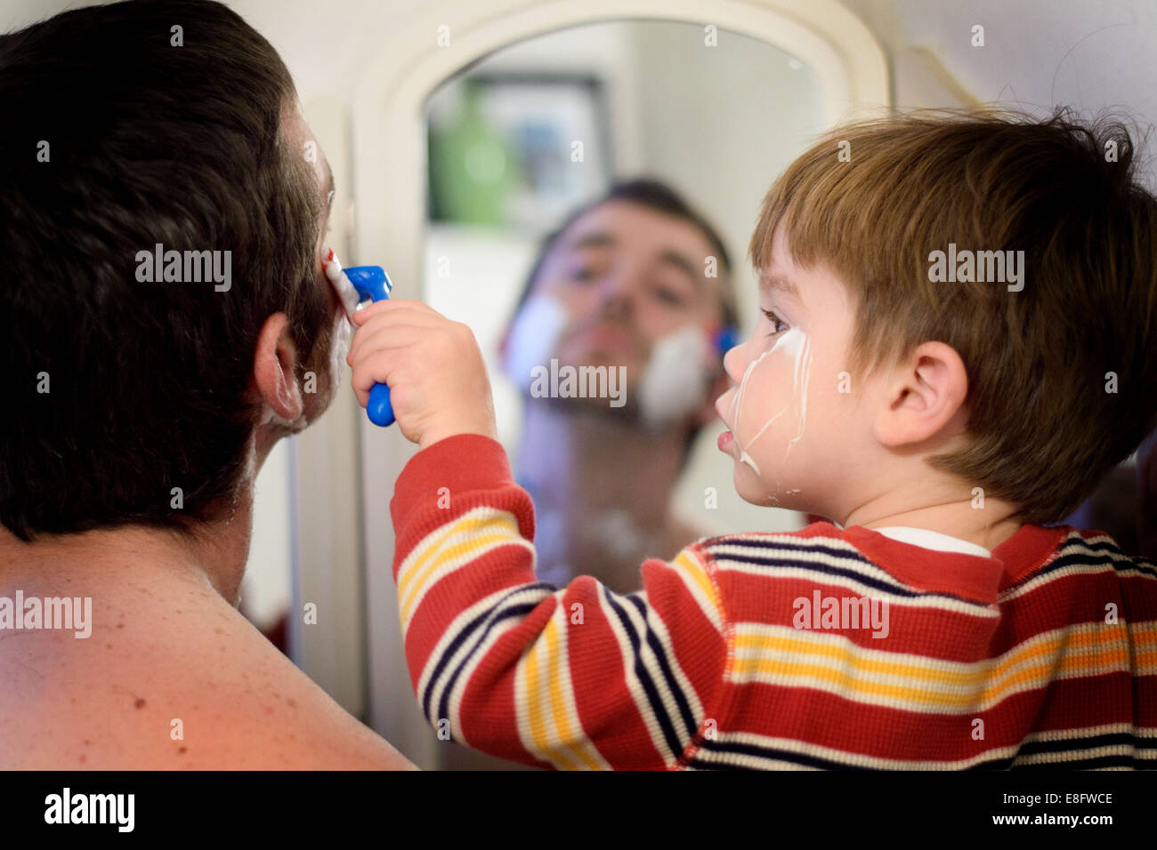 Niño ayudando a su padre a afeitarse Foto de stock