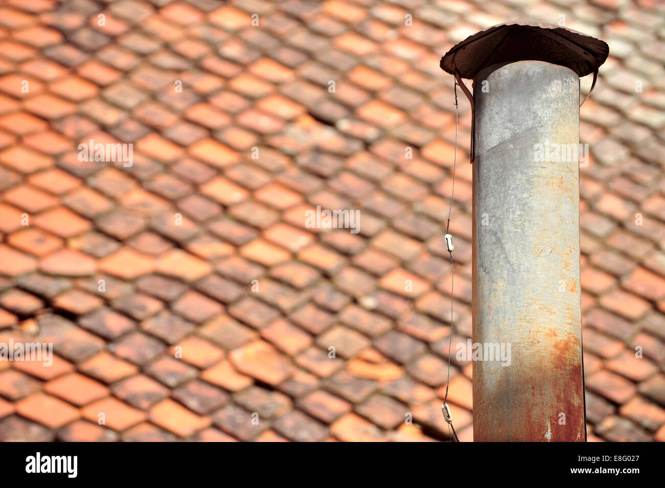 Detalle de la arquitectura lata oxidada con chimenea y techo de tejas en el fondo Foto de stock