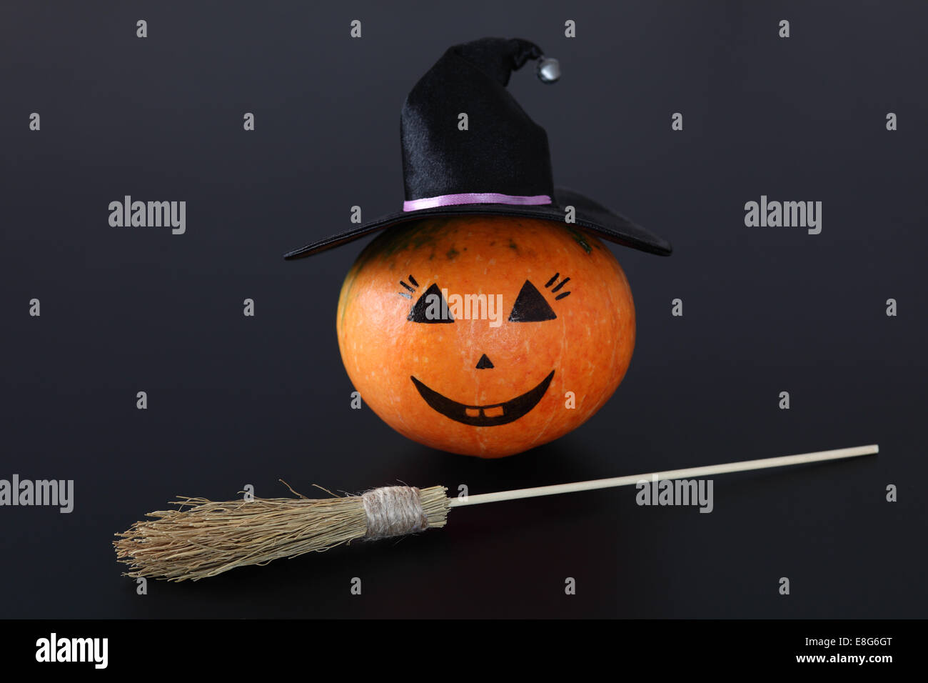Calabaza de Halloween con sombrero de bruja y la escoba de brujas' sobre  fondo negro Fotografía de stock - Alamy