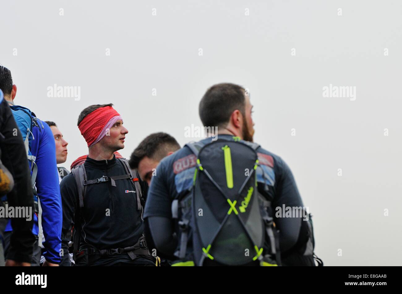 Los escaladores desde un equipo de la Marina Real mire hacia arriba a través de la neblina hacia el pico de Scafell Pike Foto de stock