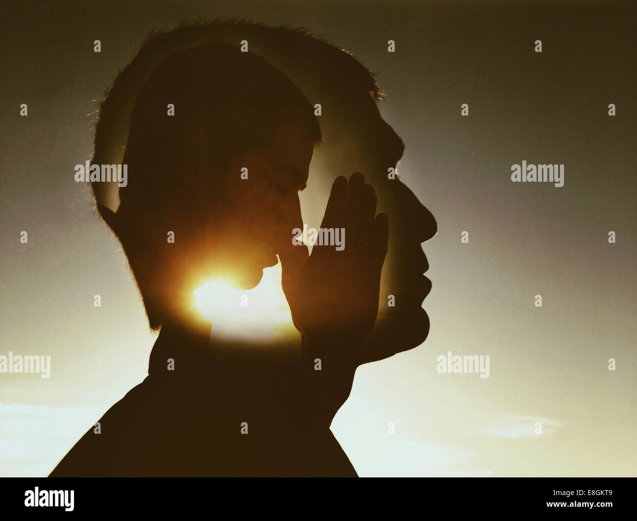 Compuesto digital de hombre orando dentro de la cabeza de un hombre Foto de stock