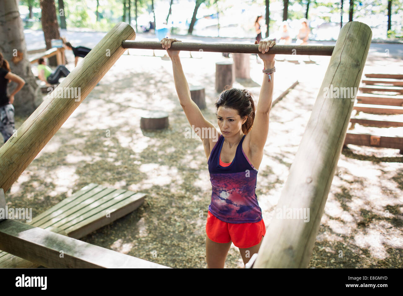 Determinada mujer levantar barra de madera en el gimnasio exterior Foto de stock