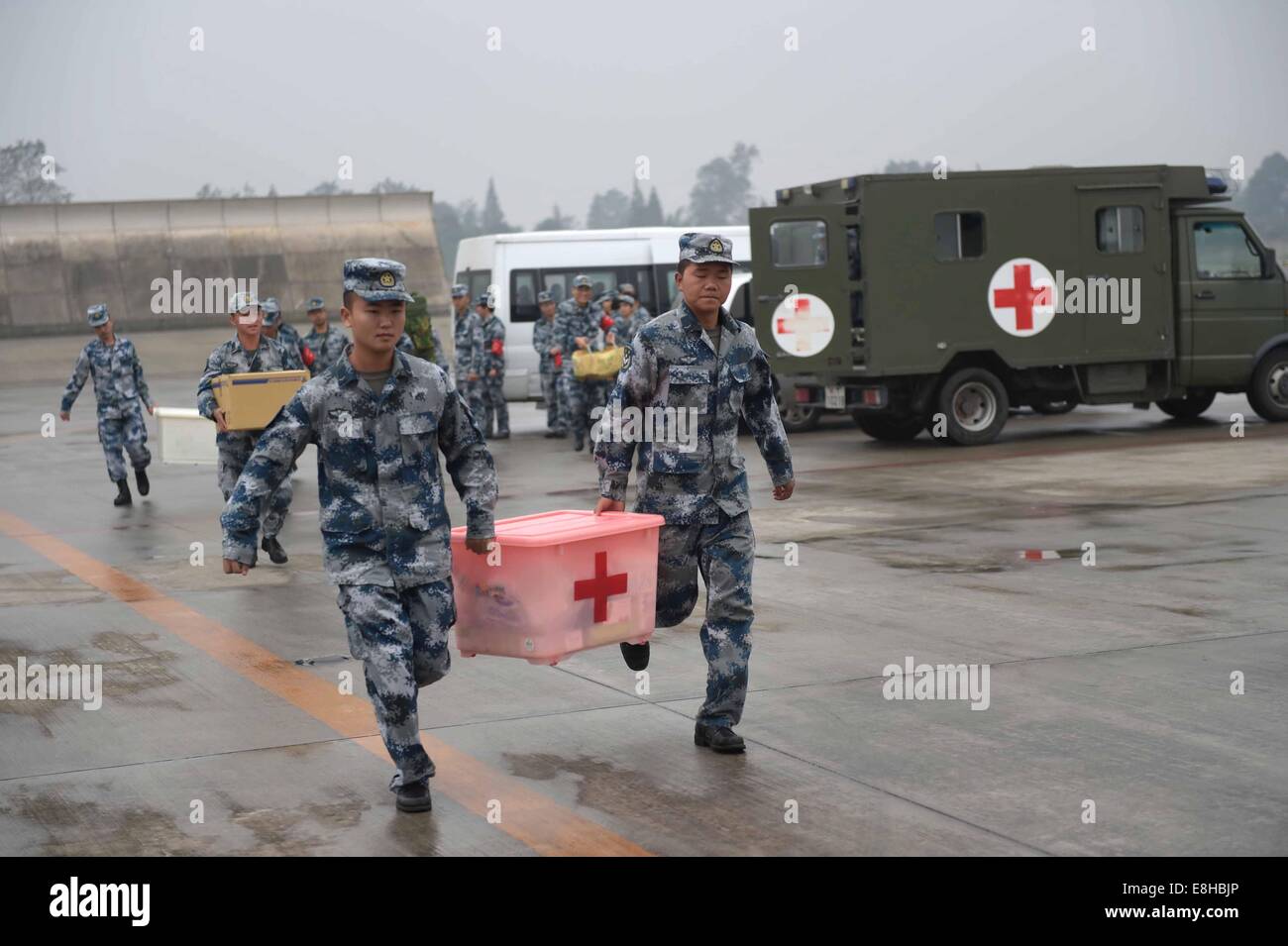 Yunnan, China. 8 de octubre de 2014. Los soldados cargar suministros médicos a las zonas afectadas por el terremoto en el aeropuerto Qionglai en el sudoeste de la provincia de Sichuan (China), el 8 de octubre de 2014. Personal médico y suministros de Chengdu han llegado de la Fuerza Aérea en el condado Jinggu el miércoles. Un terremoto de 6,6 grados de magnitud sacudió la provincia de Yunnan el martes por la noche. Crédito: Xue Yubin/Xinhua/Alamy Live News Foto de stock