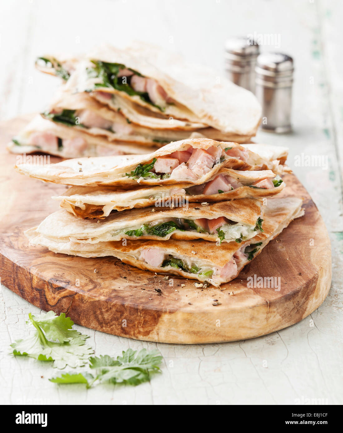 Quesadillas con queso, carne y verduras en la placa de corte en madera de olivo Fotografía de
