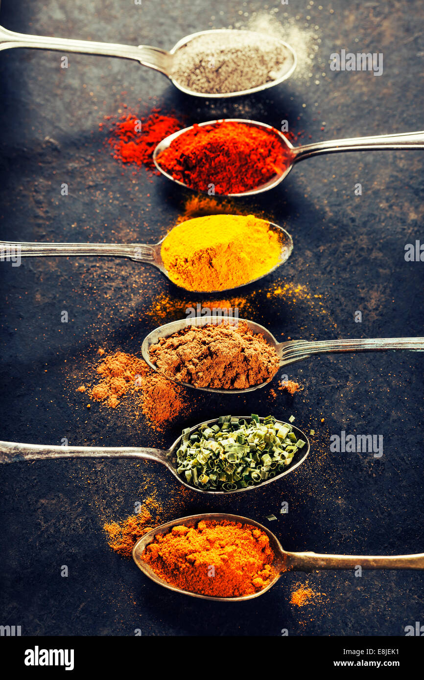 Coloridas especias en cucharas de metal - cocina bonita imagen Foto de stock