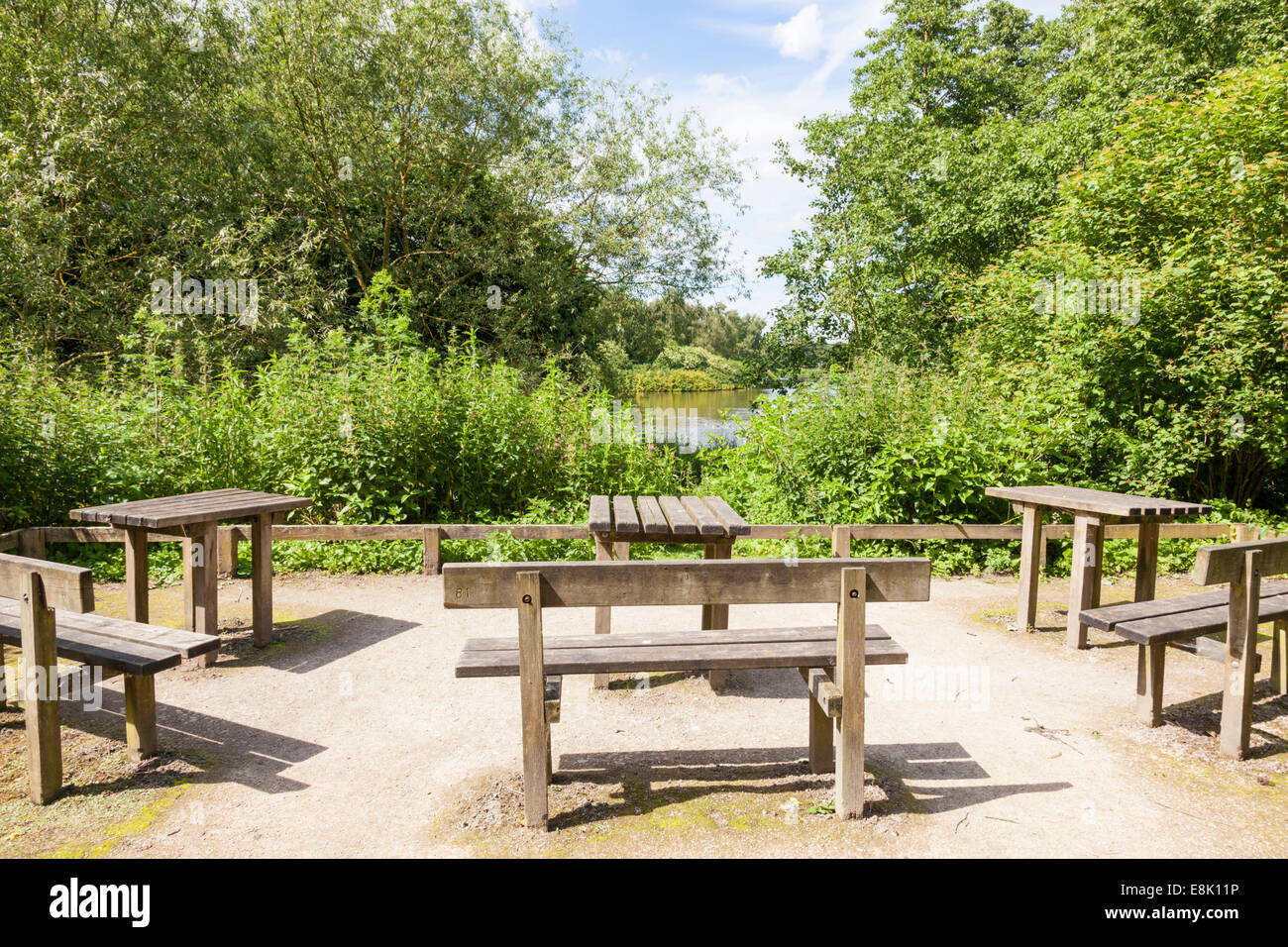 Mesas de picnic y área de asientos al aire libre con bancos de madera en los bosques en Rufford Abbey Country Park, Nottinghamshire, Inglaterra, Reino Unido. Foto de stock