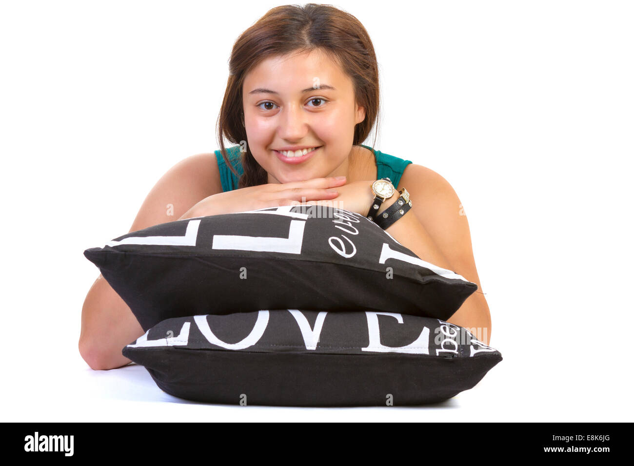 Adolescente recostada sobre almohadas sobre fondo blanco. Foto de stock