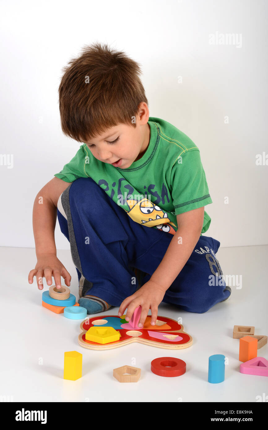Niño jugando con juegos educativos juguetes juguetes rompecabezas jigsaw uk Foto de stock