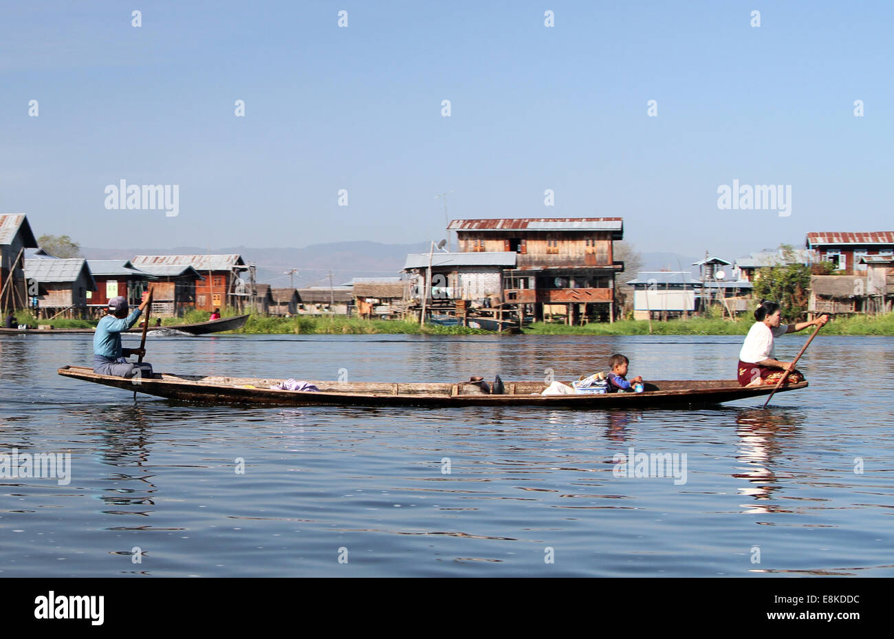 Una familia remando por el canal que une el lago Inle con la localidad de Nyaungshwe en Birmania (Myanmar) Foto de stock