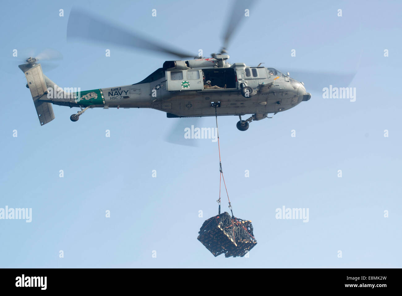 El golfo de Omán, 2 de octubre de 2013 - Un MH-60S Knighthawk ofrece la carga de la carga seca/municiones buque USNS Alan Shepard (T-AKE Foto de stock