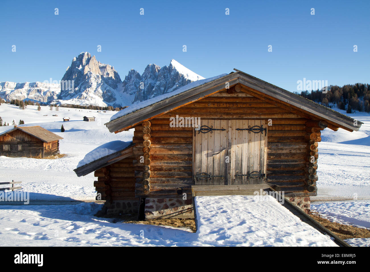 Cabañas en Seisser Alm, Italia, Sasslong Mountain en segundo plano. Foto de stock