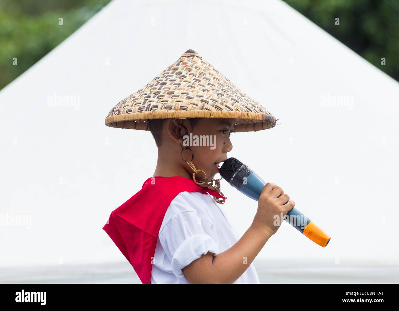 de Filipinas en traje tradicional vistiendo sombrero hecho de carrizos cantando en encuentro intercultural en España Fotografía de stock Alamy