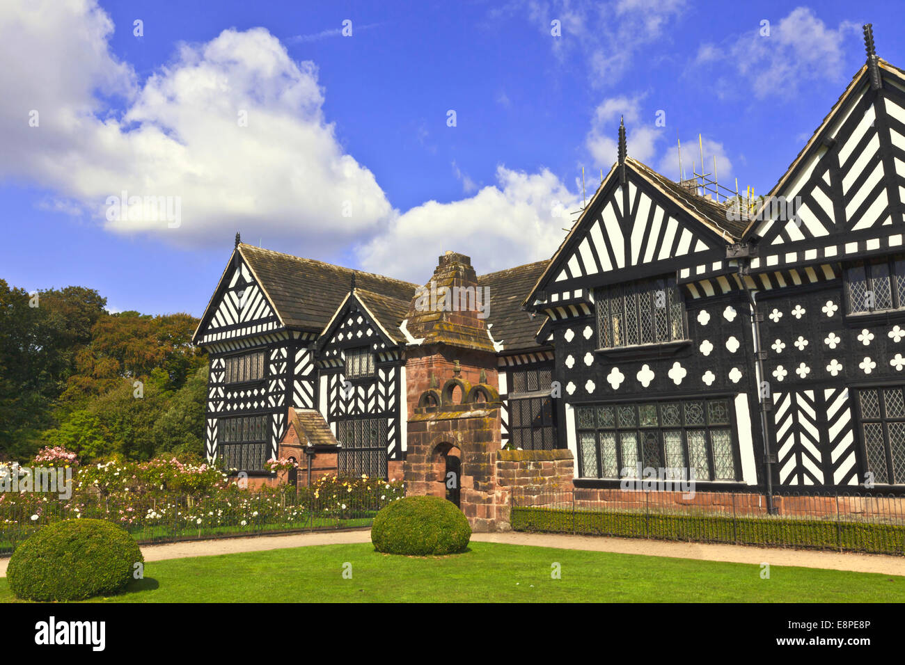 Blanco y negro mansión medieval de entramado de madera y jardines. Foto de stock