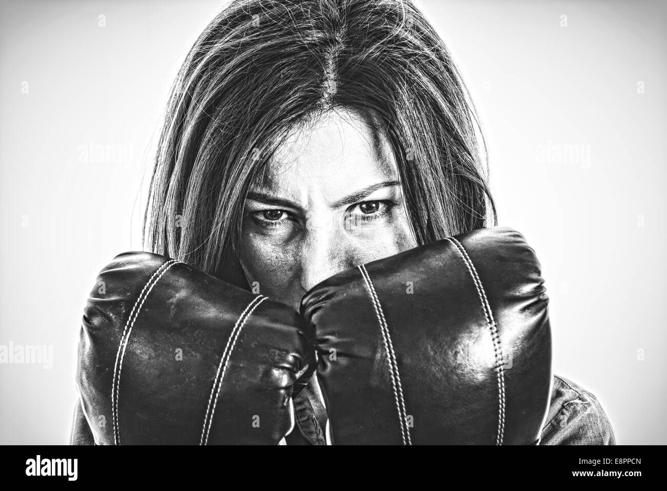 Closeup retrato de una mujer decidida de boxeador. Confiado, valiente y furiosa mujer de negocios moderno con guantes de boxeo en Isola Foto de stock