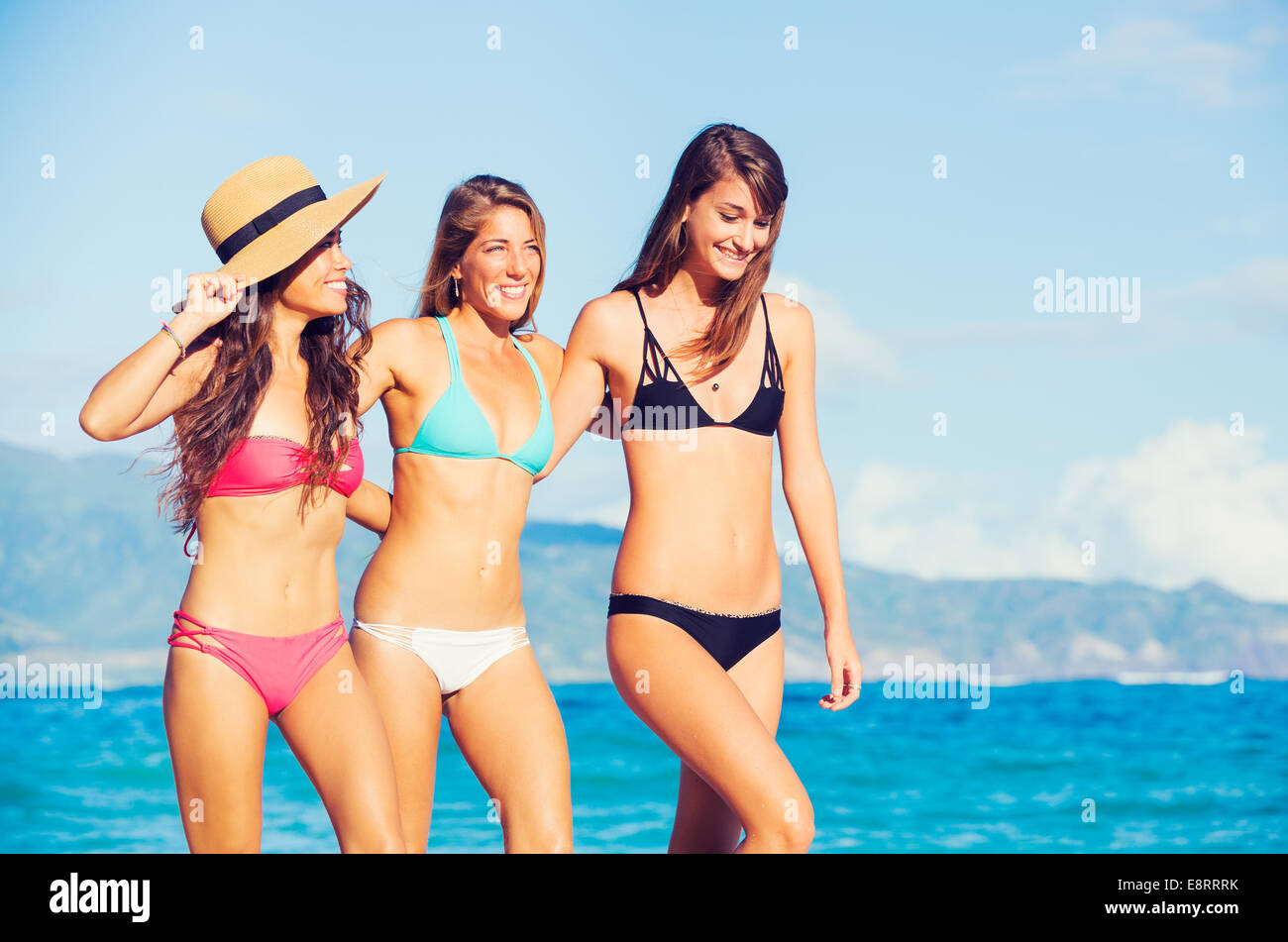 Grupo de Tres hermosas jóvenes y atractivas mujeres que caminan en la playa Foto de stock
