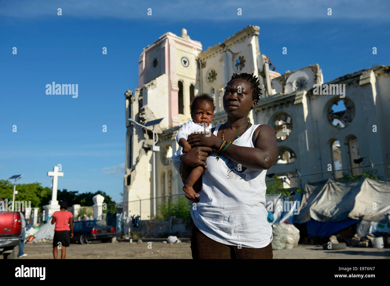 Mujer sosteniendo un niño en frente de las ruinas de la catedral, destruida por el terremoto de 2012, Port-au-Prince, Haití Foto de stock