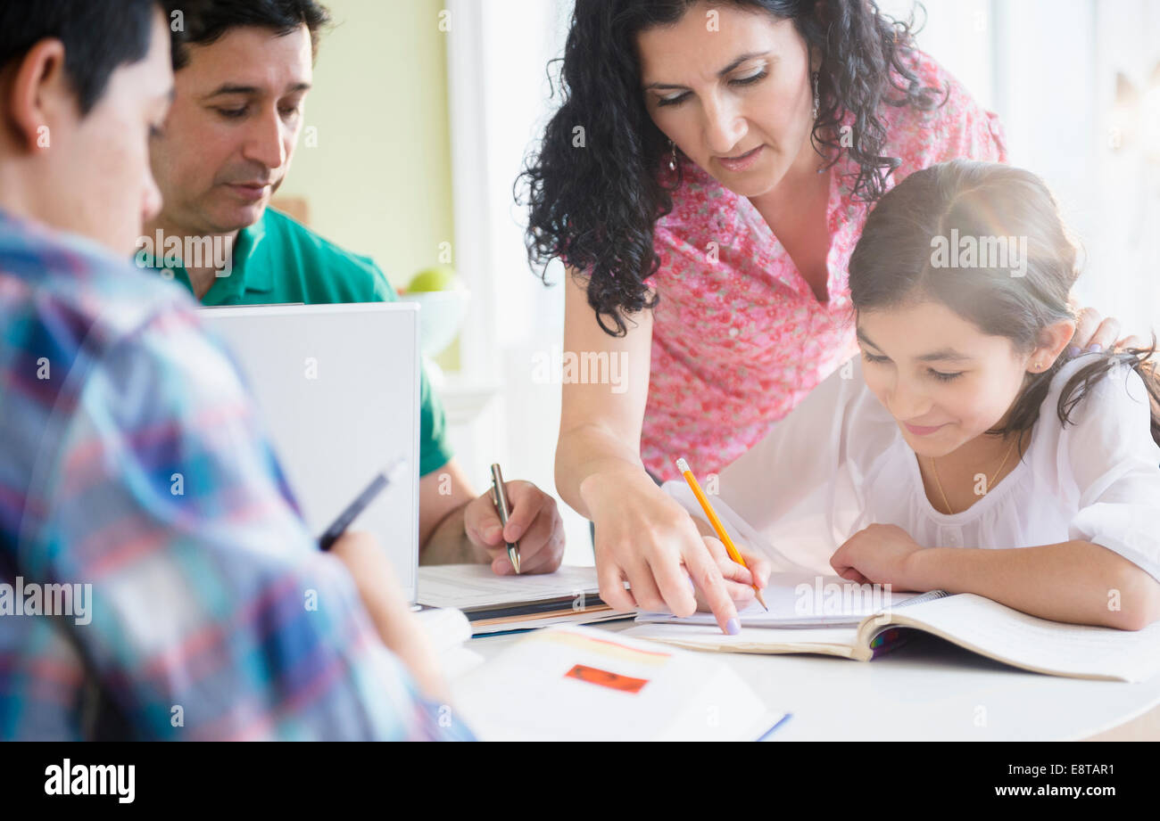 Familia hispana haciendo los deberes juntos en la mesa Foto de stock