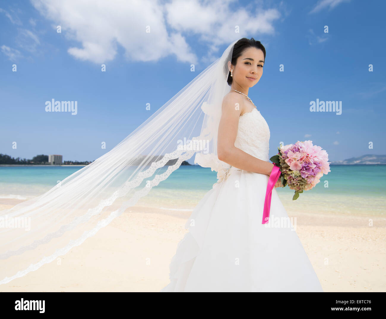 Mestizos, Asiáticos / American bride en blanco vestido de boda en boda en la playa de destino en Okinawa, Japón Foto de stock