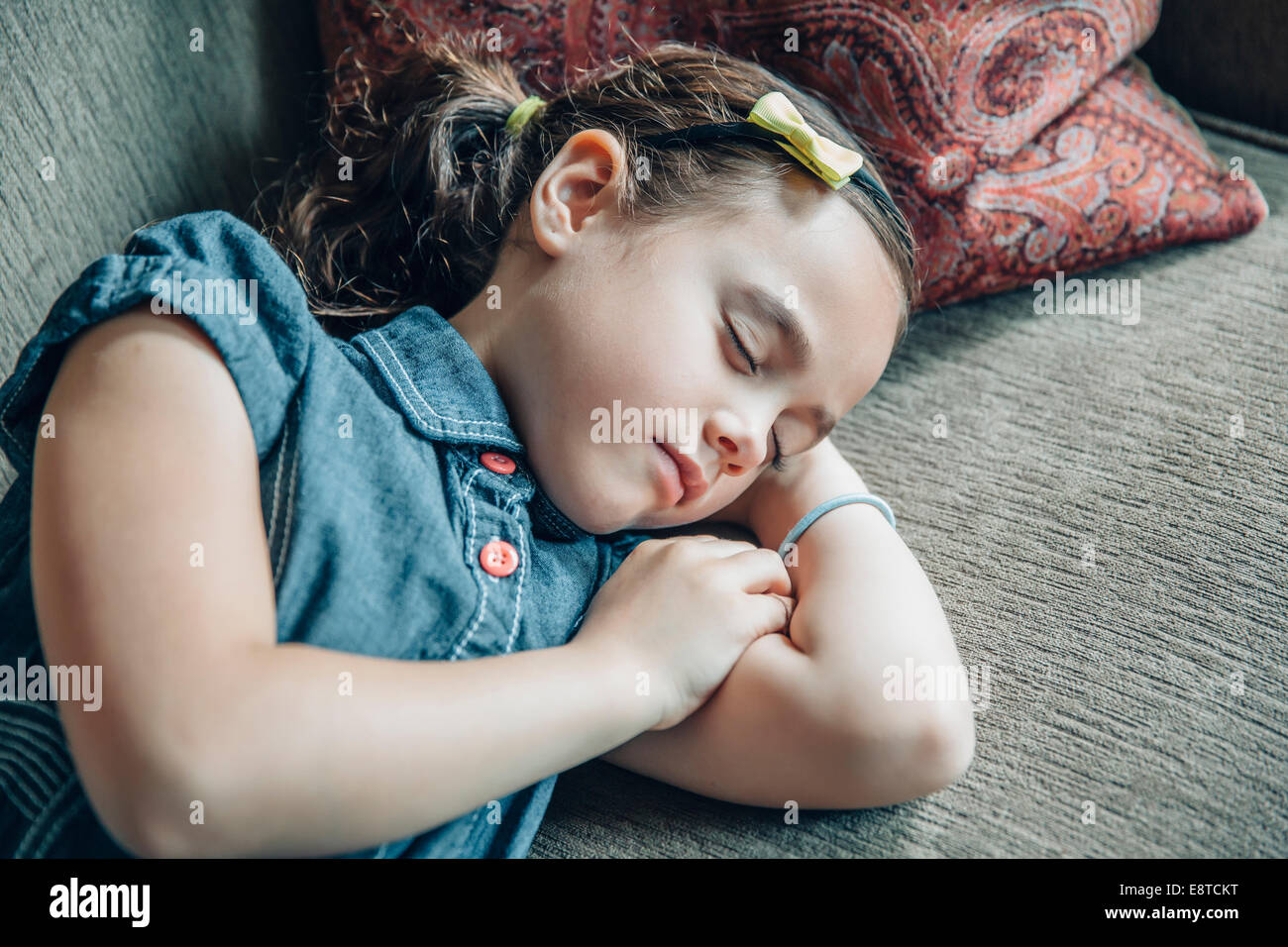 Raza mixta chica durmiendo en el sofá Foto de stock