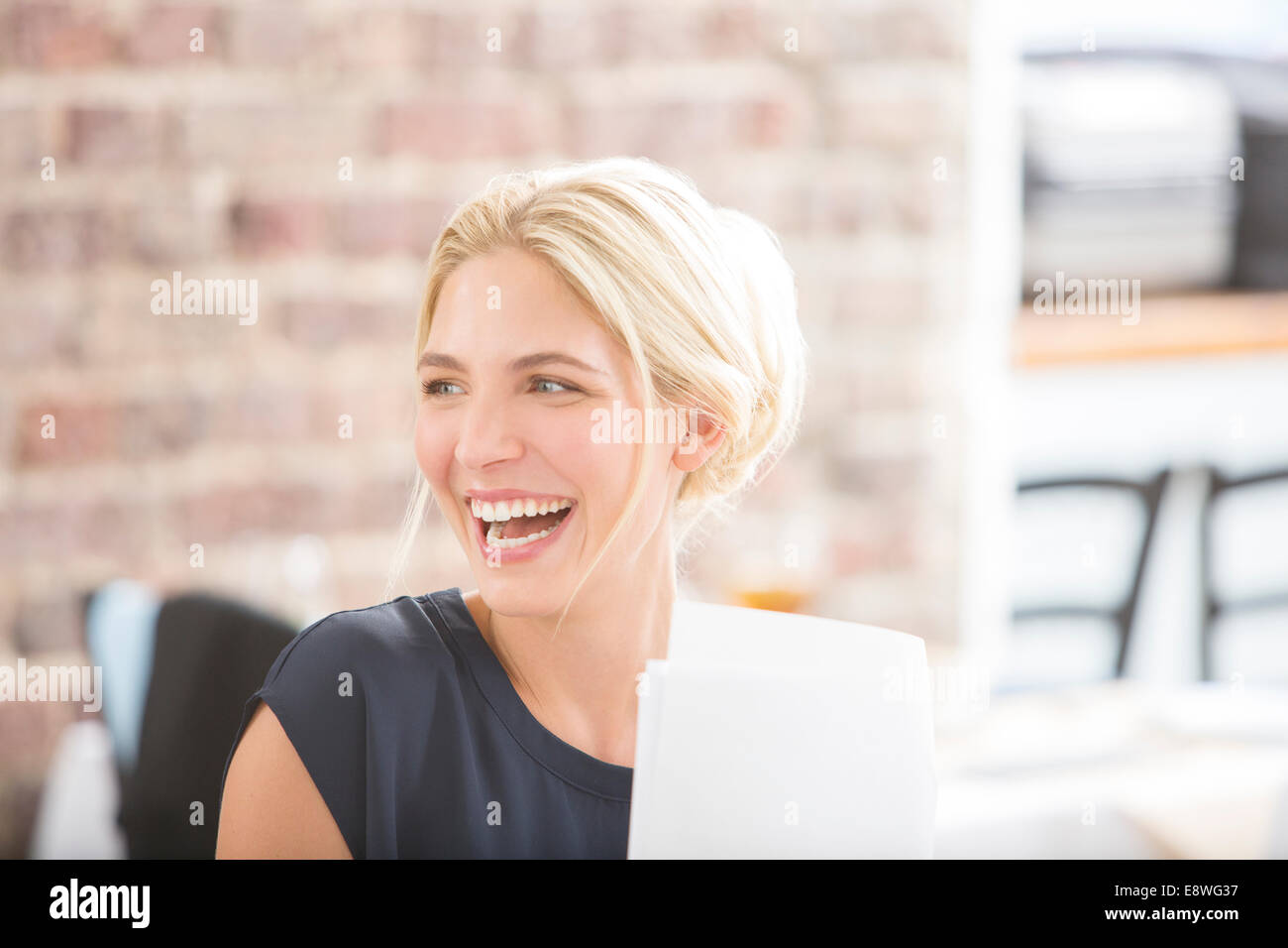 Mujer riendo en Office Foto de stock