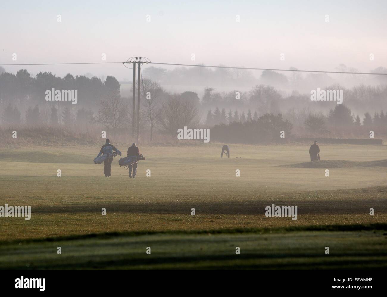 Los golfistas en Minchinhampton Golf Club, disfrutar del sol por la mañana temprano, Minchinhampton, Gloucestershire. 19 Ene 2014 Foto de stock