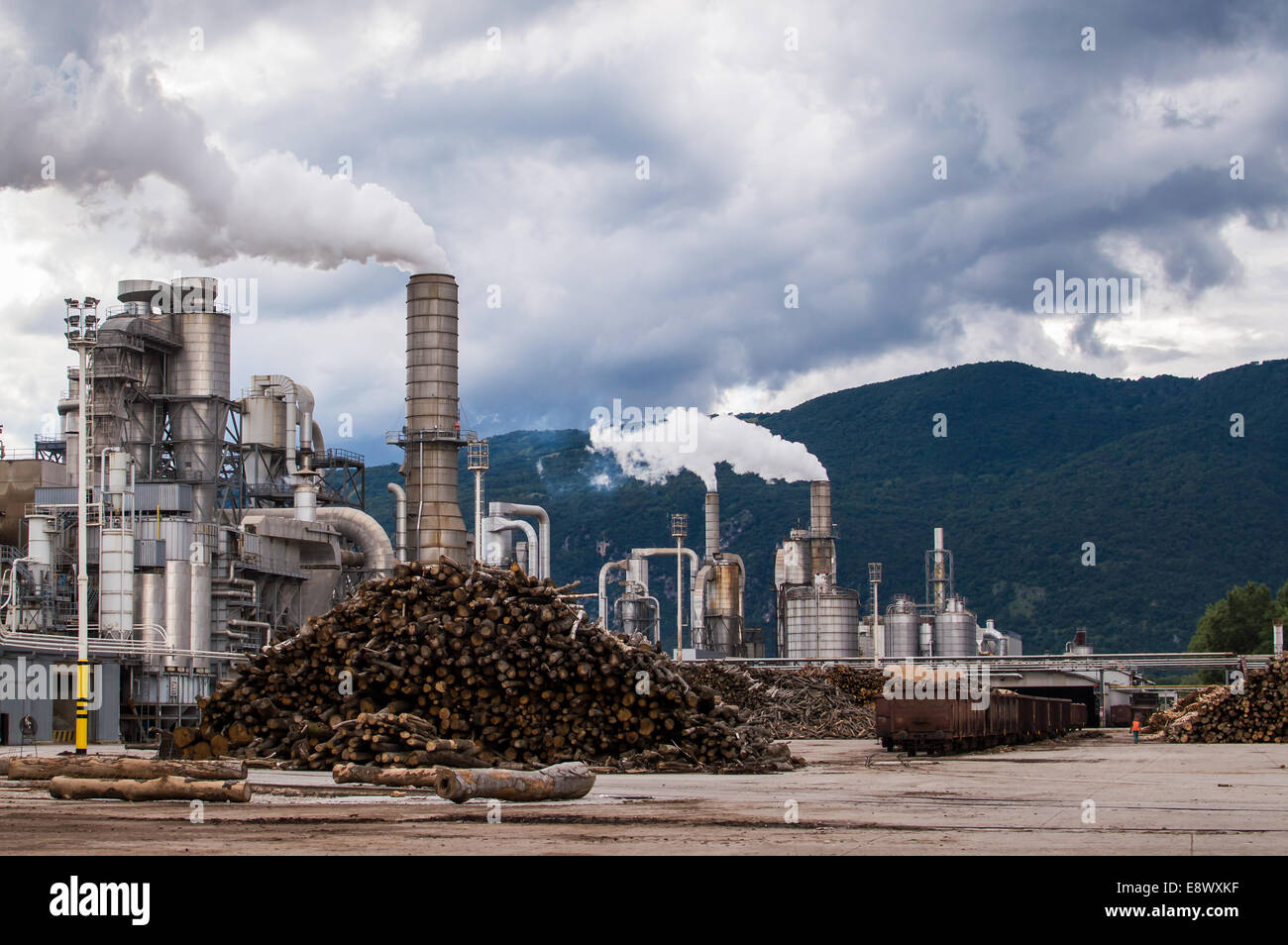 La planta industrial de una fábrica de muebles con fumar chimeneas en cielo tormentoso Foto de stock