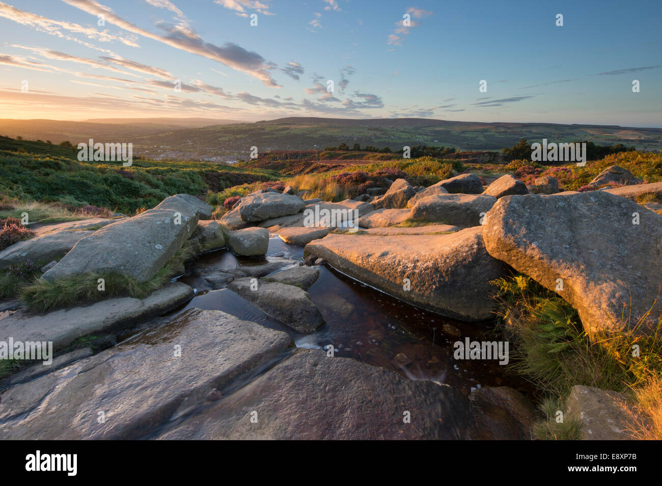 Bajo el espectacular cielo brillante, vista pintoresca rural al atardecer desde lo alto de Ilkley Moor, sobre la ciudad enclavada en el valle de Wharfe - West Yorkshire, Inglaterra, Reino Unido. Foto de stock