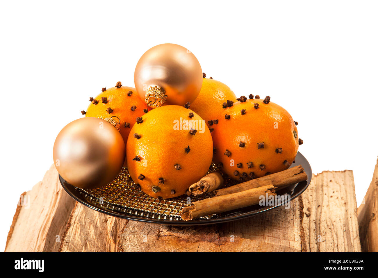 Naranja y bolas de navidad con palitos de canela en la leña sobre fondo blanco. Foto de stock