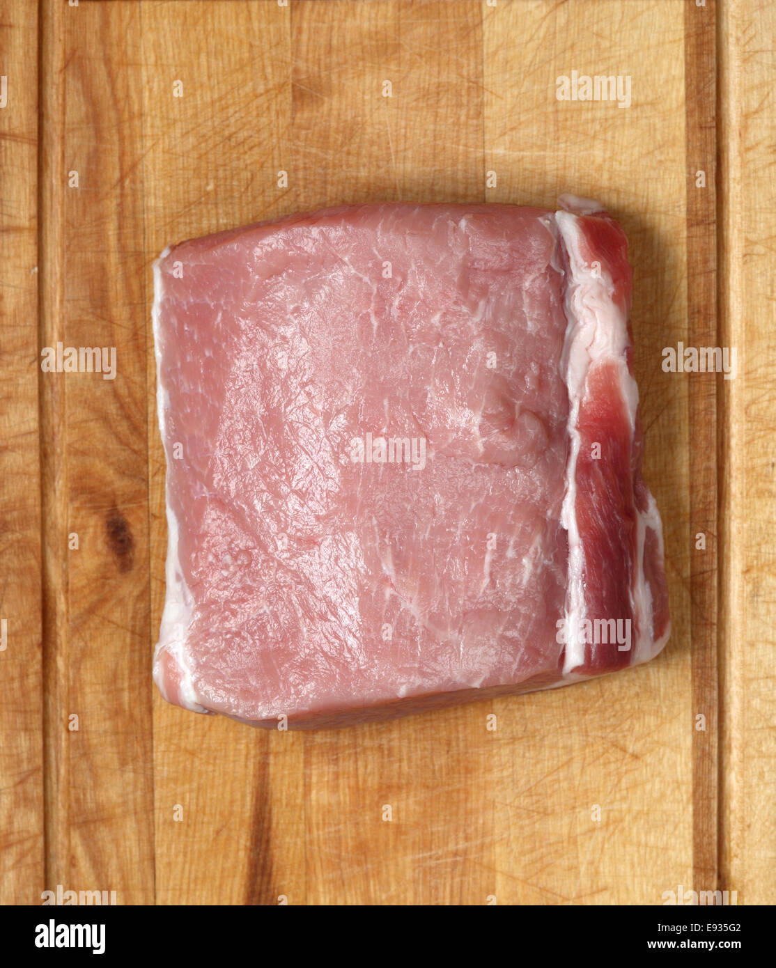 Lomo de cerdo cruda sobre un fondo de madera Foto de stock