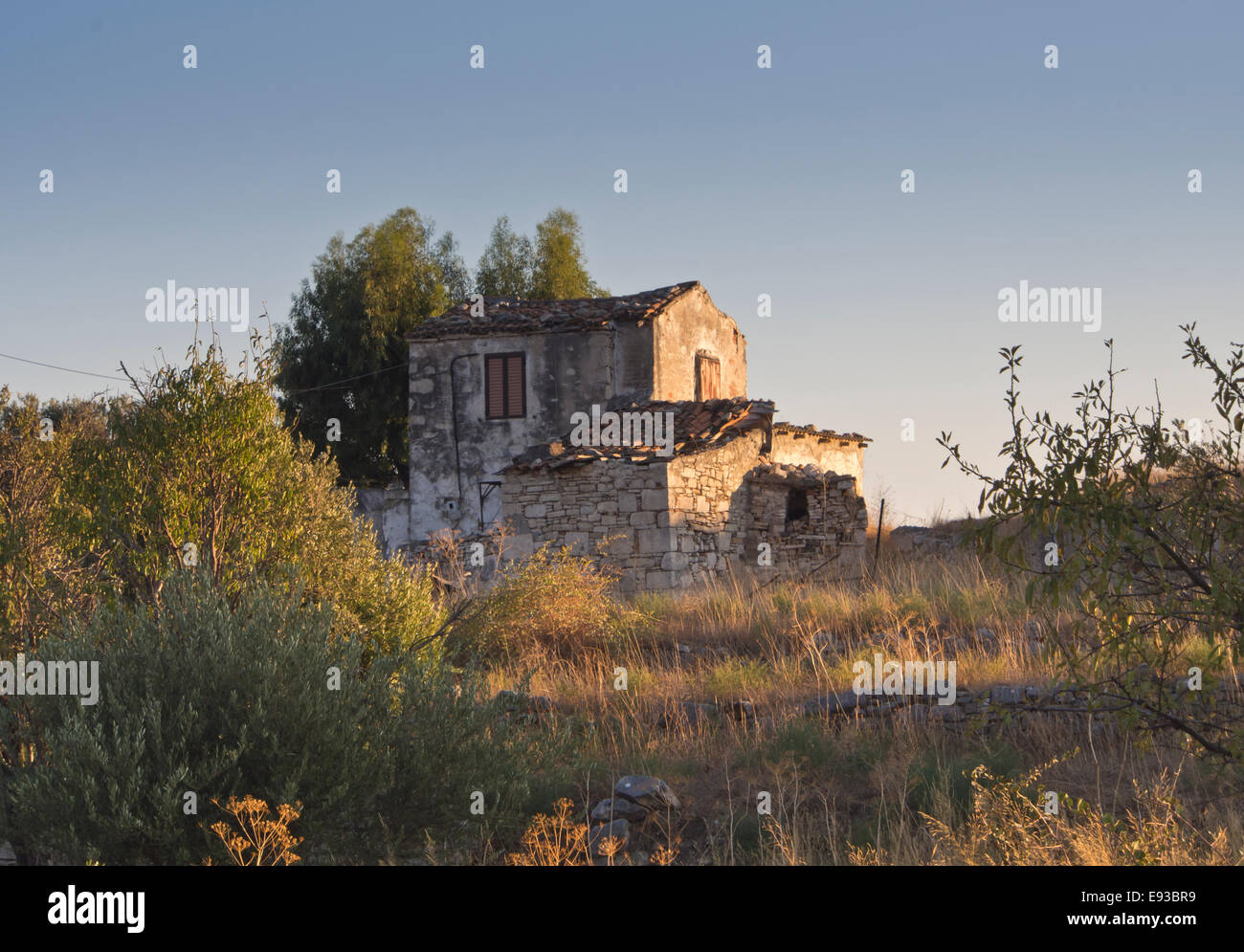 Vacío griego casa de piedra en la cima de una colina en golden luz del atardecer, Samos Grecia Foto de stock