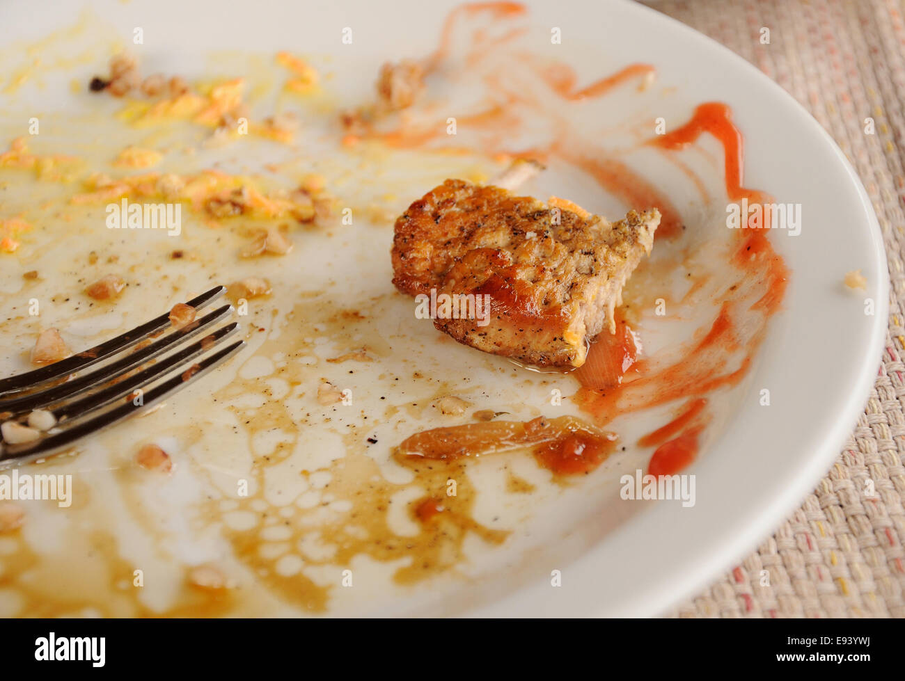 Medio comido trozo de carne sobre el plato blanco sucio Foto de stock