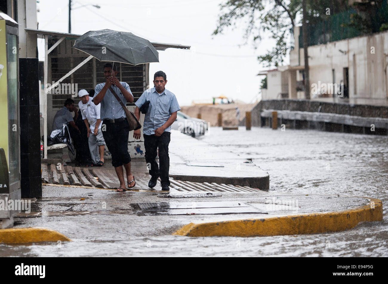 Guerrero, México. 19 Oct, 2014. Un hombre sostiene un paraguas bajo la  lluvia, en el puerto de Acapulco, Guerrero, México, el 19 de octubre, 2014.  La intensa lluvia generada por la tormenta