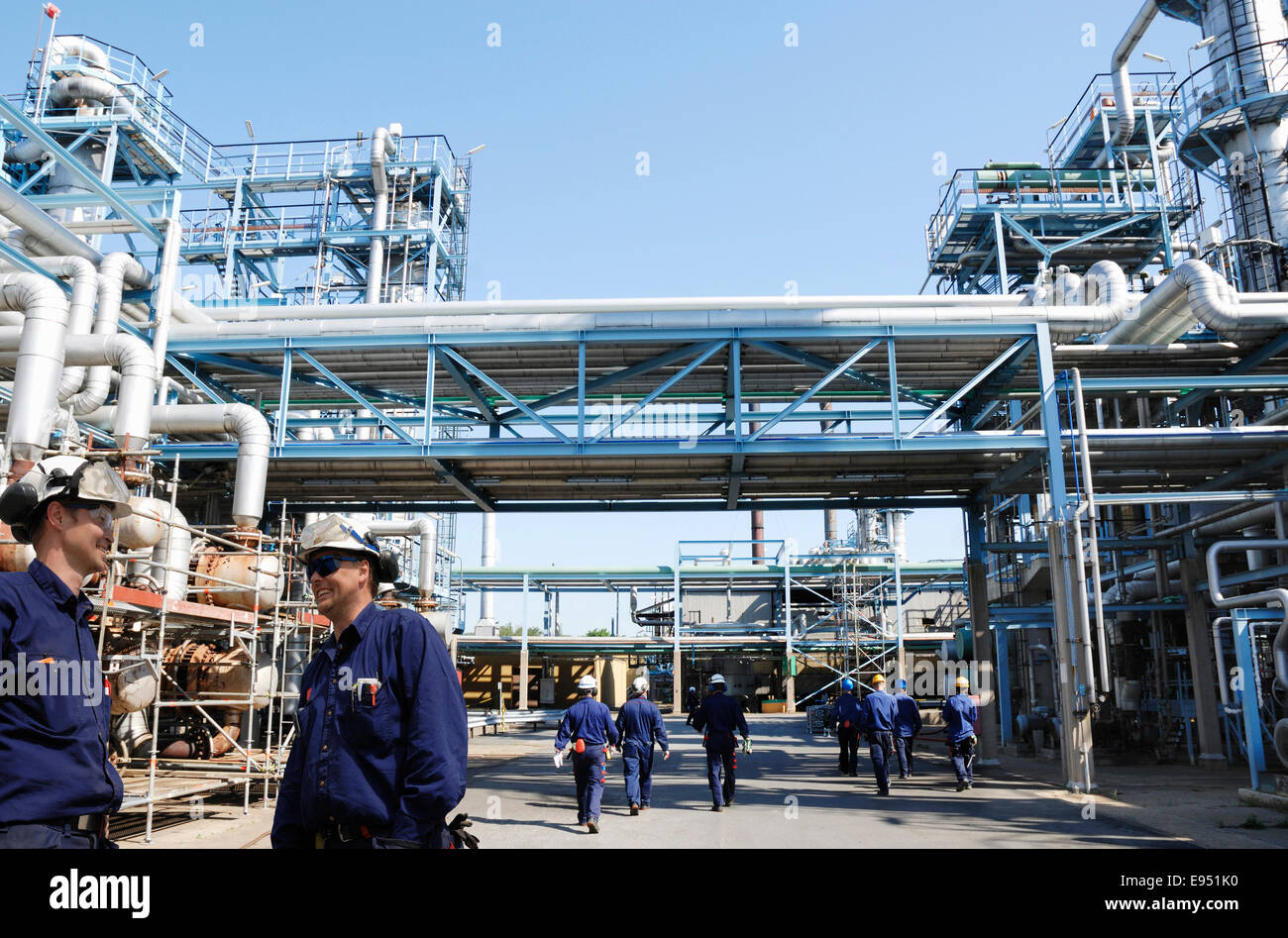 Los trabajadores de petróleo y gas dentro del gran refinería Foto de stock