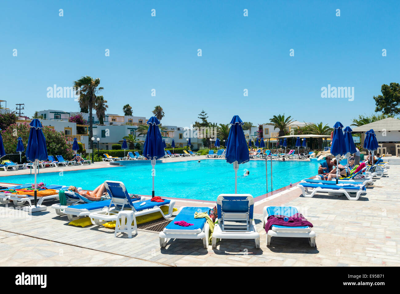 Vacaciones en la piscina, reposeras y sombrillas, soun Mastichari, Kos, Grecia Foto de stock
