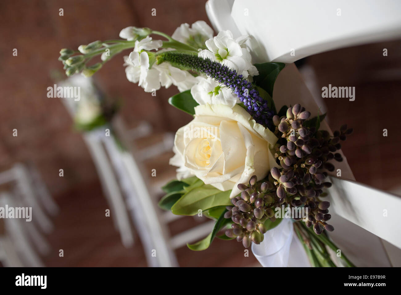 Flores decorativas en las sillas de iglesia para boda Foto de stock