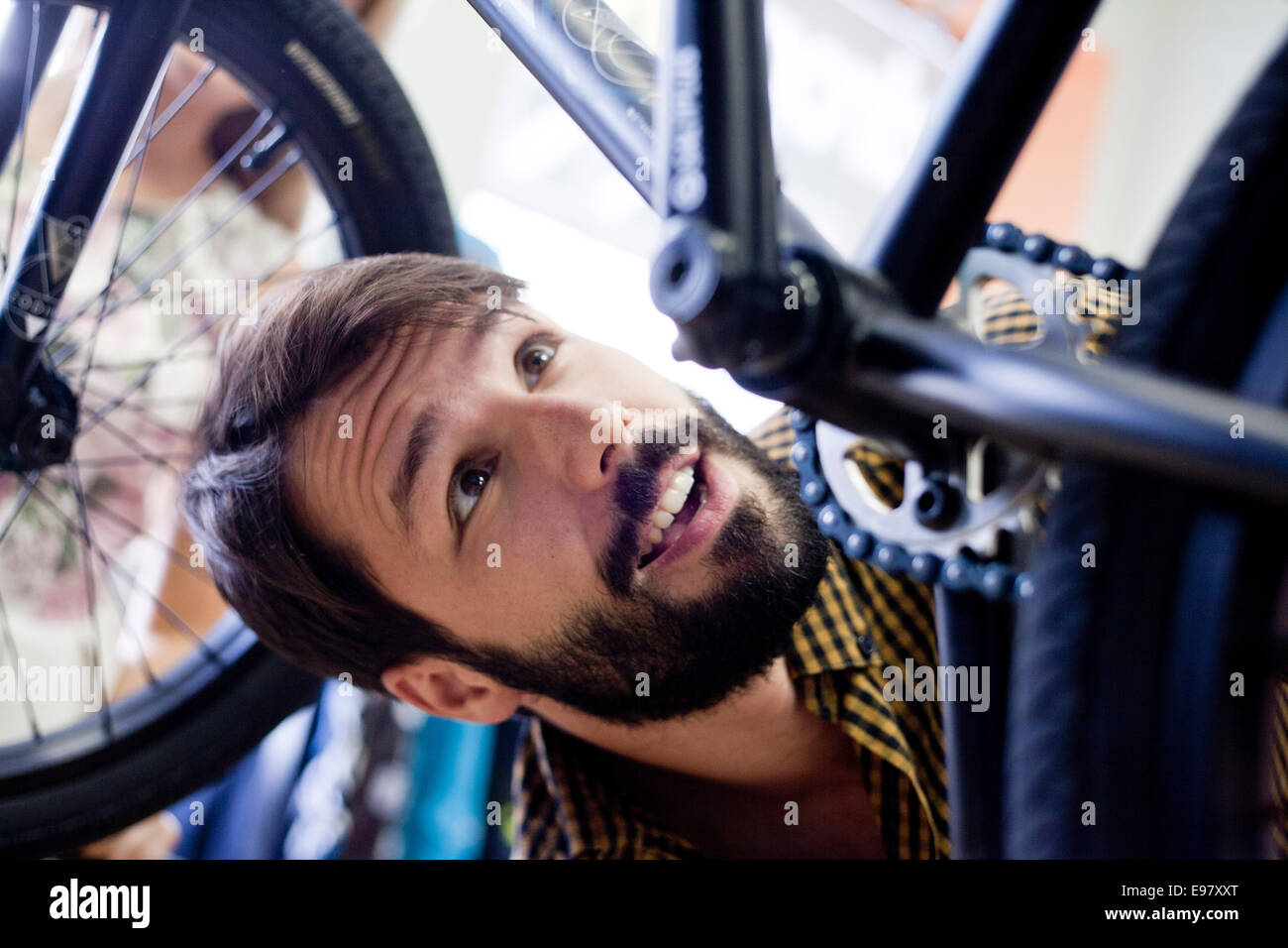 El hombre en la tienda de bicicletas buscando en bicicleta