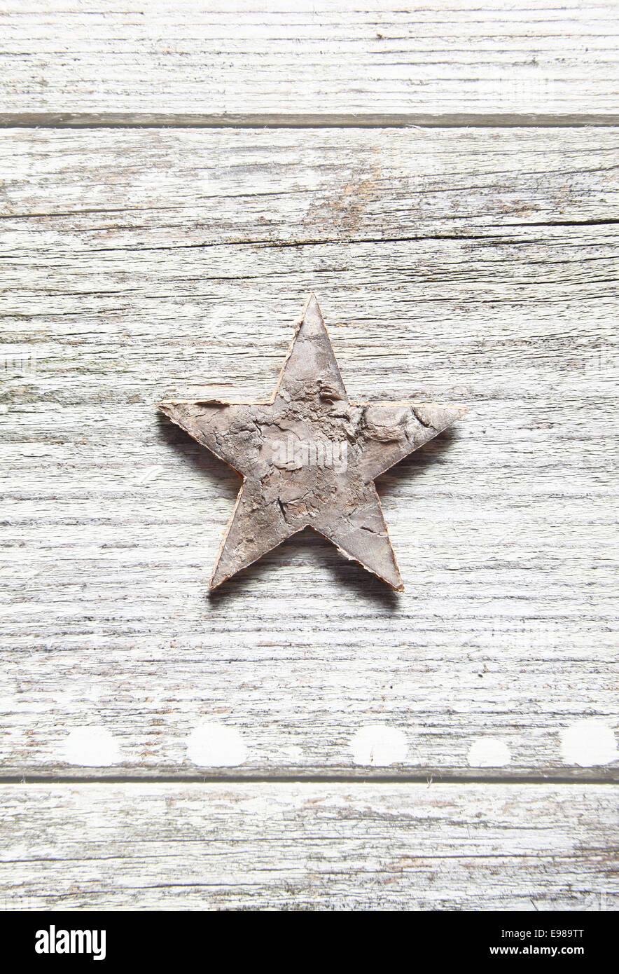 Sucio antigua estrella de Navidad centrado verticalmente sobre tablones de madera veteada erosionados y copyspace Foto de stock