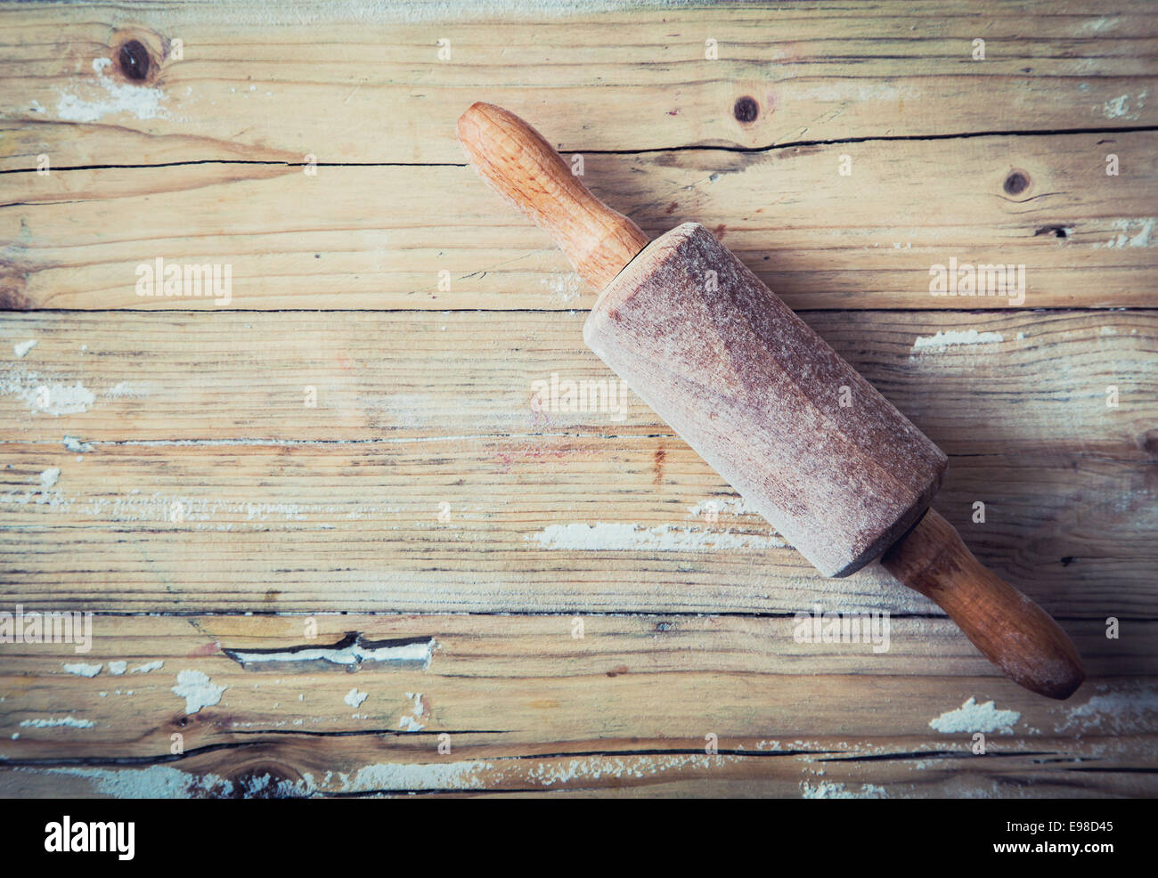 Rodillo de madera vieja sobre un fondo de madera grunge con restos de harina dispersos remanentes de Vista cenital con copyspace para hornear Foto de stock