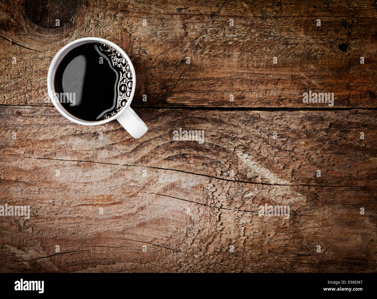 Vista aérea de una taza de café recién hecho de café espresso en rústicas de madera con fondo de textura de madera veteada y grietas, con copyspace Foto de stock