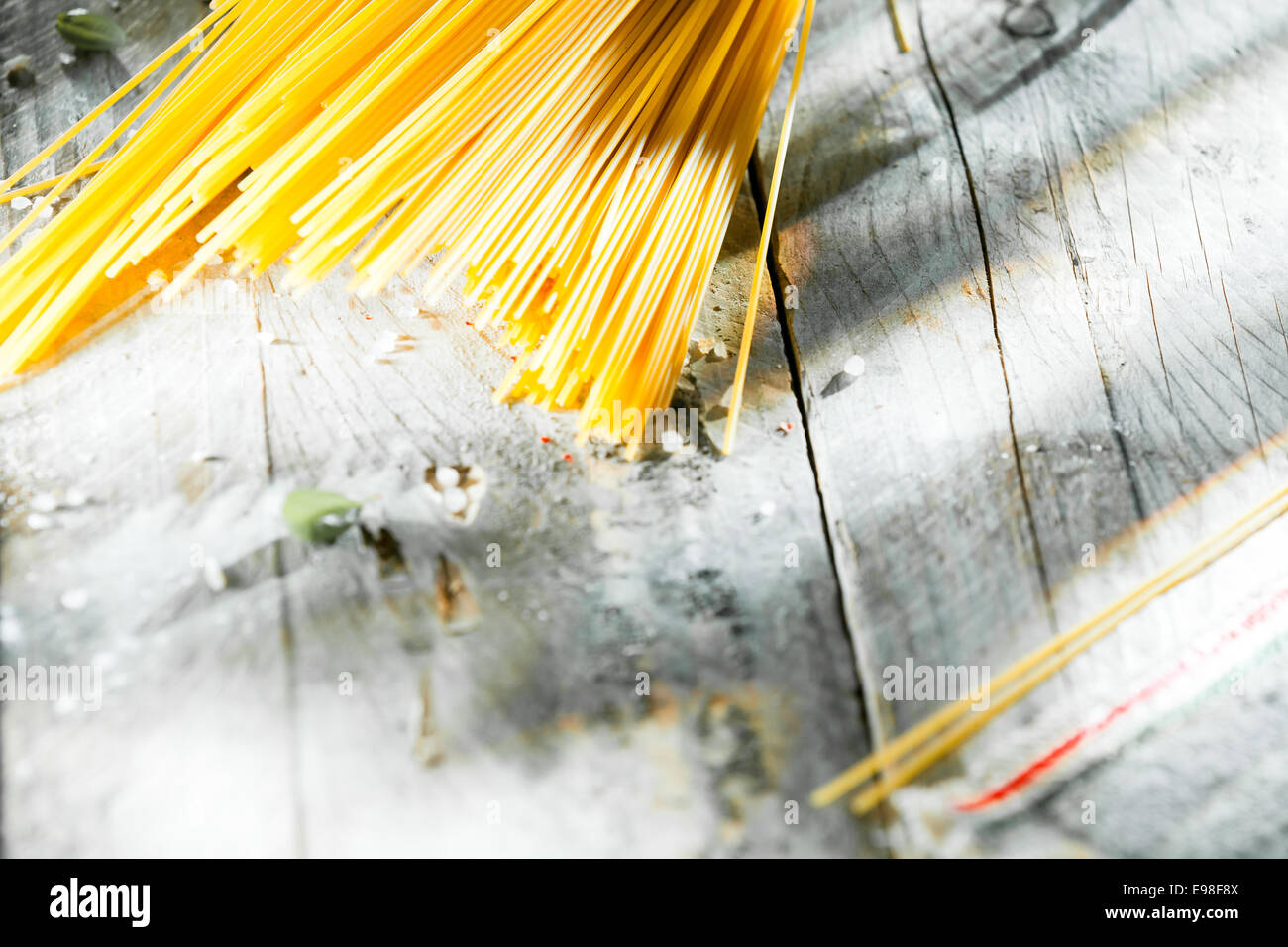 Fideos spaghetti italiano hechas de masa de trigo durm secos dispuestos en la esquina de una mesa de madera sucio en ángulo con copyspace Foto de stock