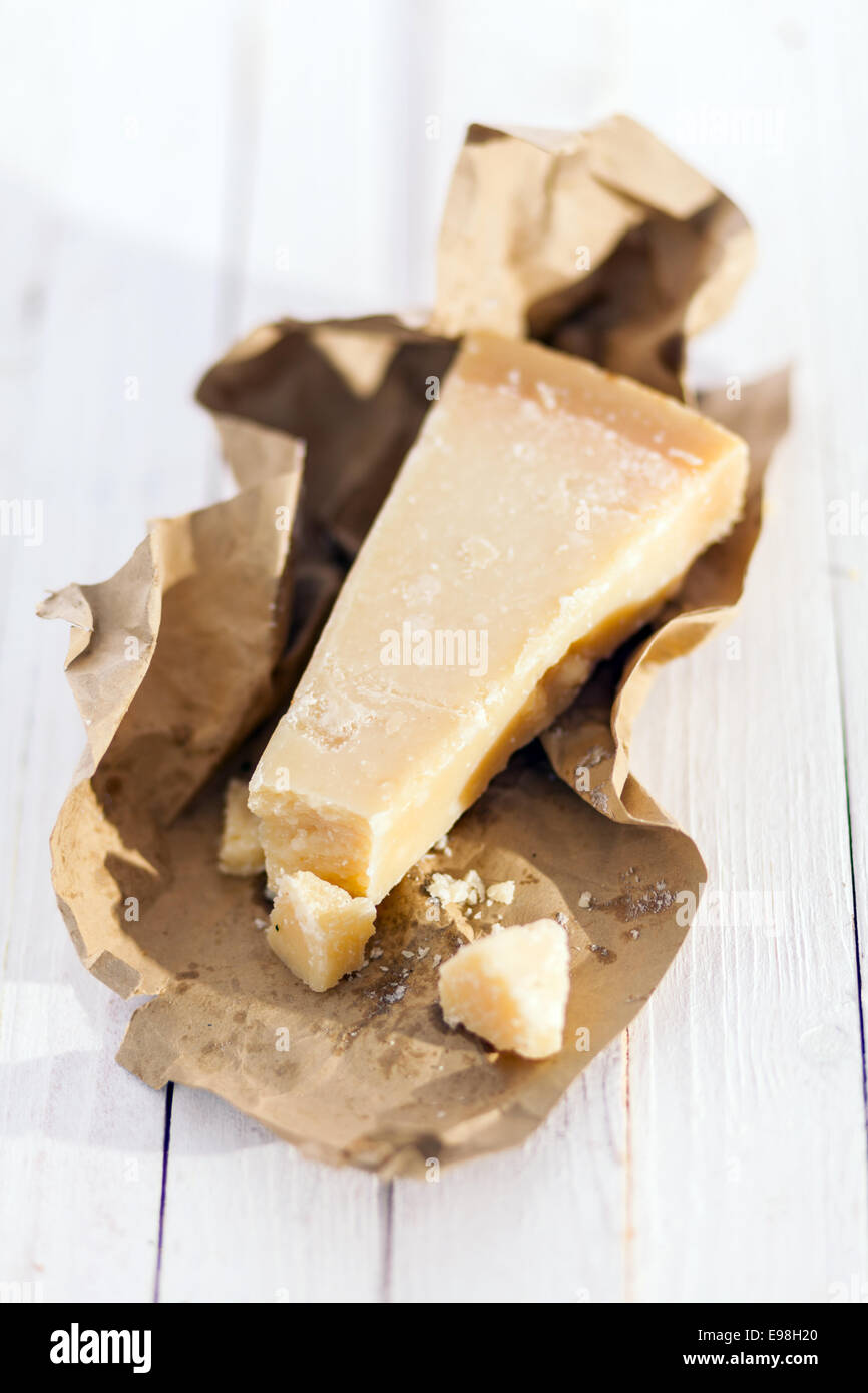 Cuña de lujo Parmigiano-Reggiano queso italiano exclusivo de determinadas provincias de Italia en un envoltorio de papel marrón listo para ser Foto de stock