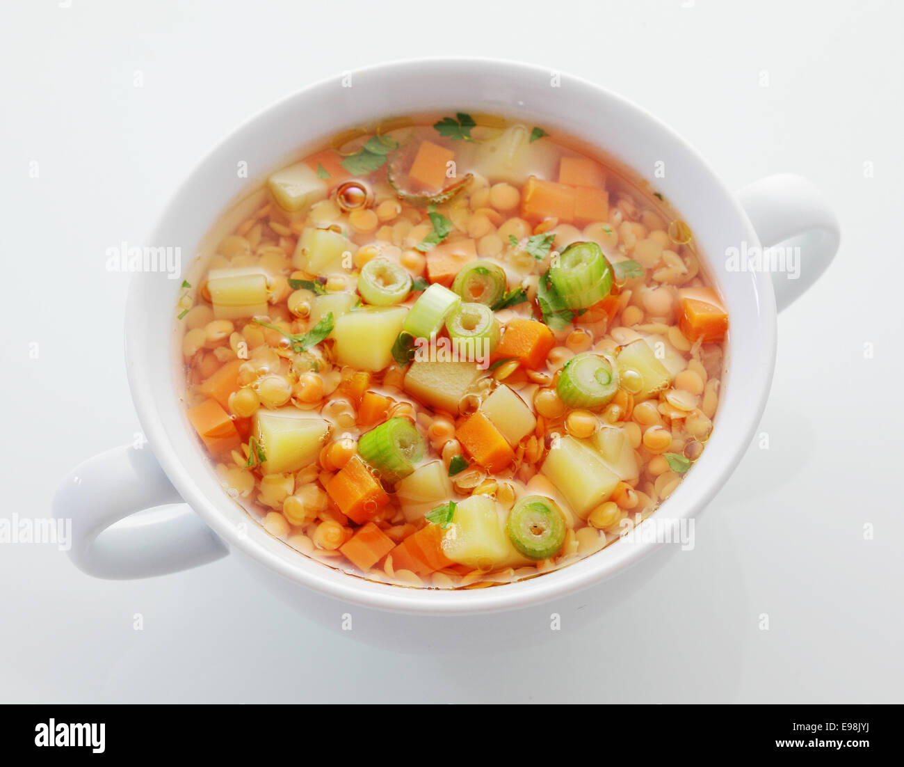 Saludable plato de lentejas, zanahoria y sopa de puerro rico en proteínas y fibra dietética, un alto ángulo de visualización en blanco Foto de stock