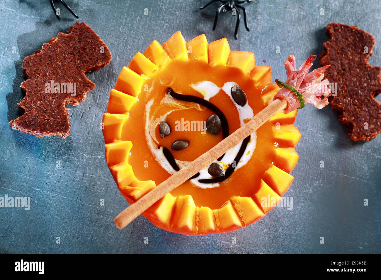 Se sirve sopa de calabaza de Halloween en la mitad de una calabaza con forma de murciélago Crouton tostadas y escoba Pan Stick desde arriba Foto de stock