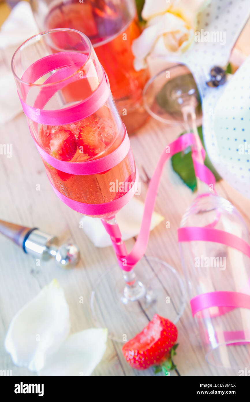 Elegante champagne flauta llena con champán y fresas en un tratamiento decorativo de mesa en una celebración Foto de stock