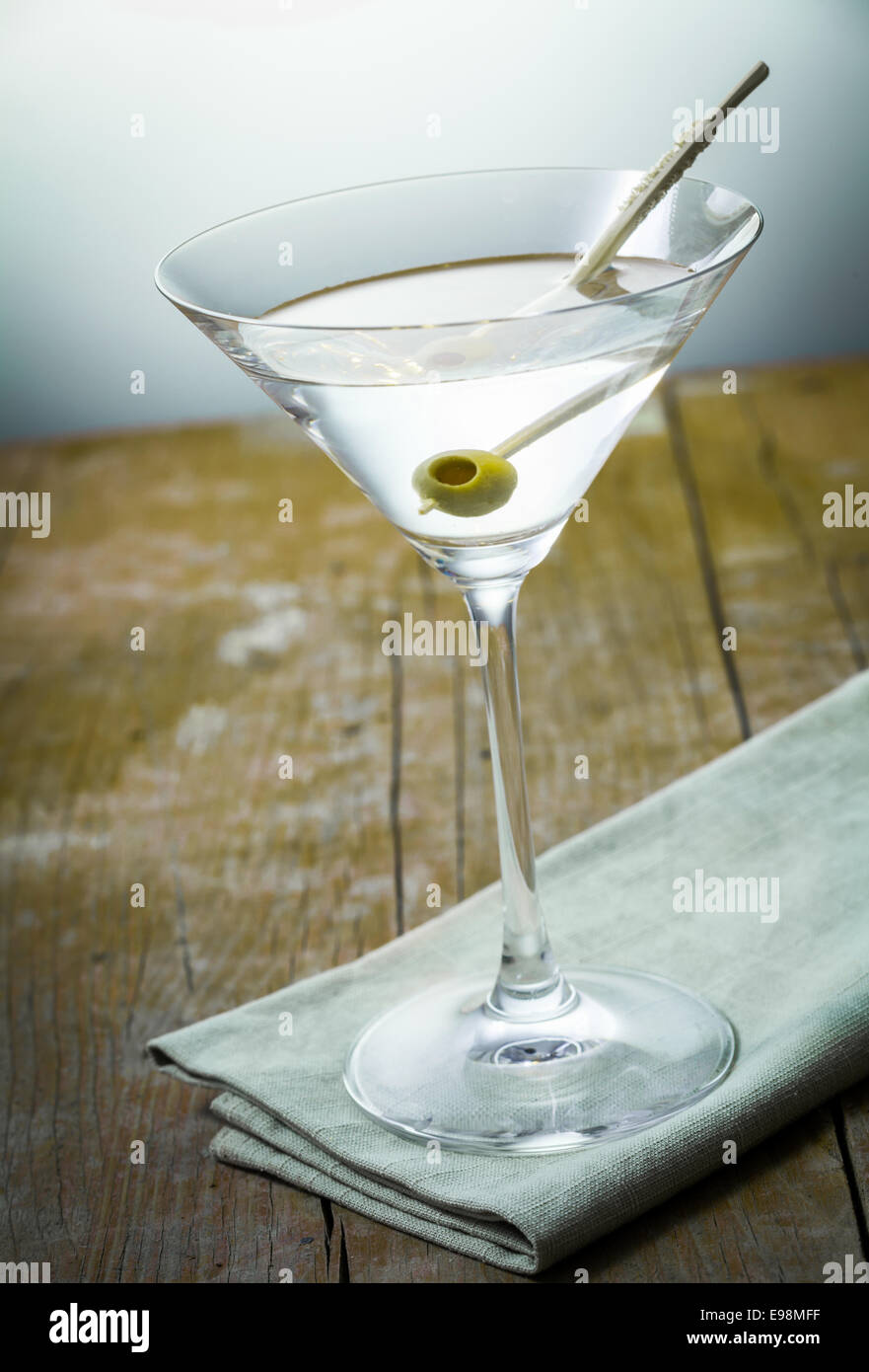 bebidas con una aceituna en un vaso de cóctel de pie sobre una servilleta más rústicos tablones Fotografía de stock - Alamy