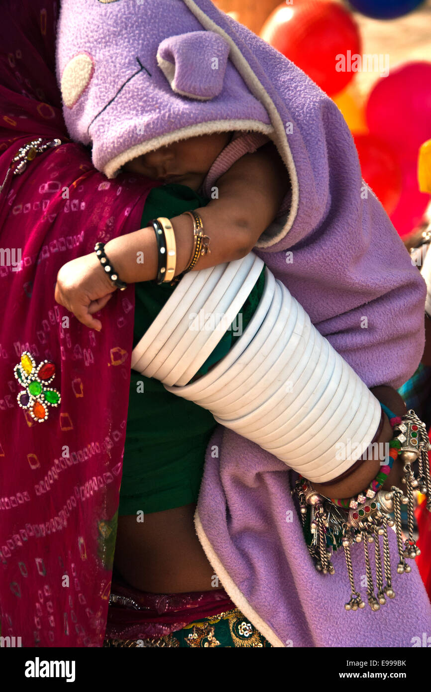 Niña dormida en brazos de su madre, Udaipur, Rajasthan, India Foto de stock