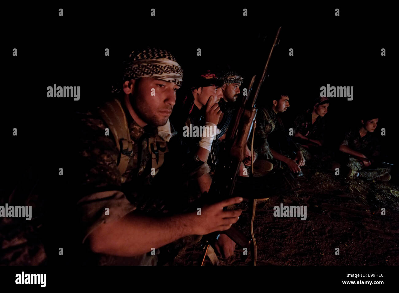 Combatientes de las unidades de protección del pueblo kurdo YPG emplazamiento alrededor de una hoguera en Al-hasakah Hassakeh o distrito en el norte de Siria Foto de stock